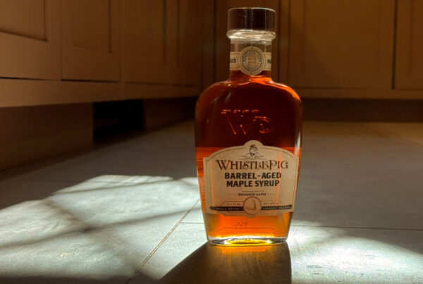 Barrel-aged maple syrup bottle photographed in winter light as an everyday luxury ritual.