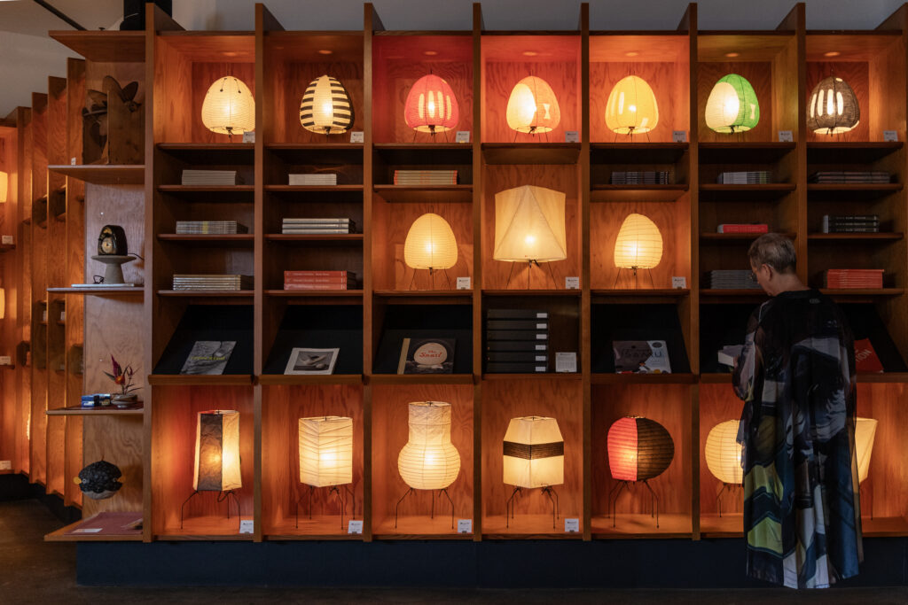 Wall of glowing Akari light sculptures at The Noguchi Museum Shop in Queens, New York, photographed by Pamela Thomas-Graham.