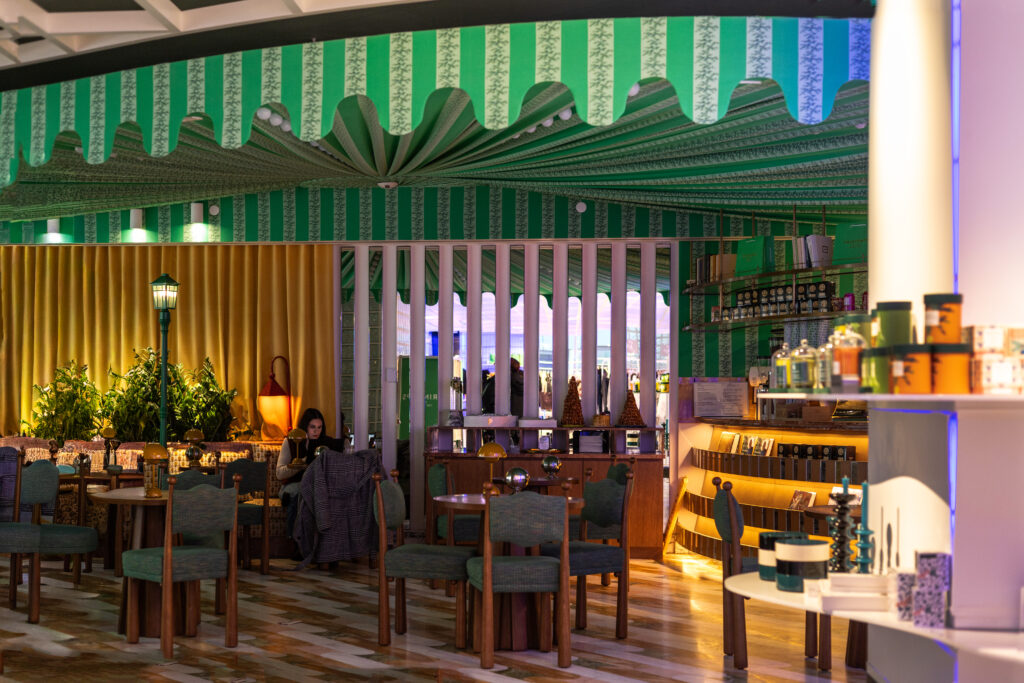 Books, upholstered seating, and table lamps inside Café Jalu at Printemps New York, creating an intellectual and library-like atmosphere.