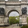 Rain-soaked view of the Soldiers’ and Sailors’ Memorial Arch at Grand Army Plaza in Brooklyn, a Civil War monument with bronze sculptural groups.