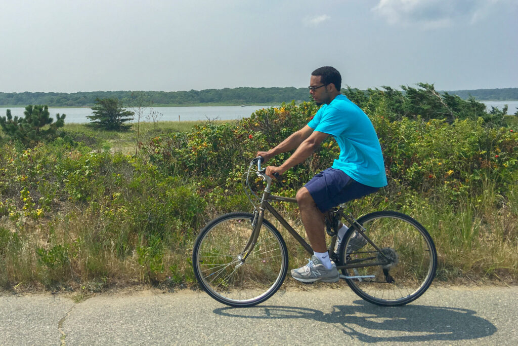 Man riding a bicycle along a road in Oak Bluffs on Martha’s Vineyard.