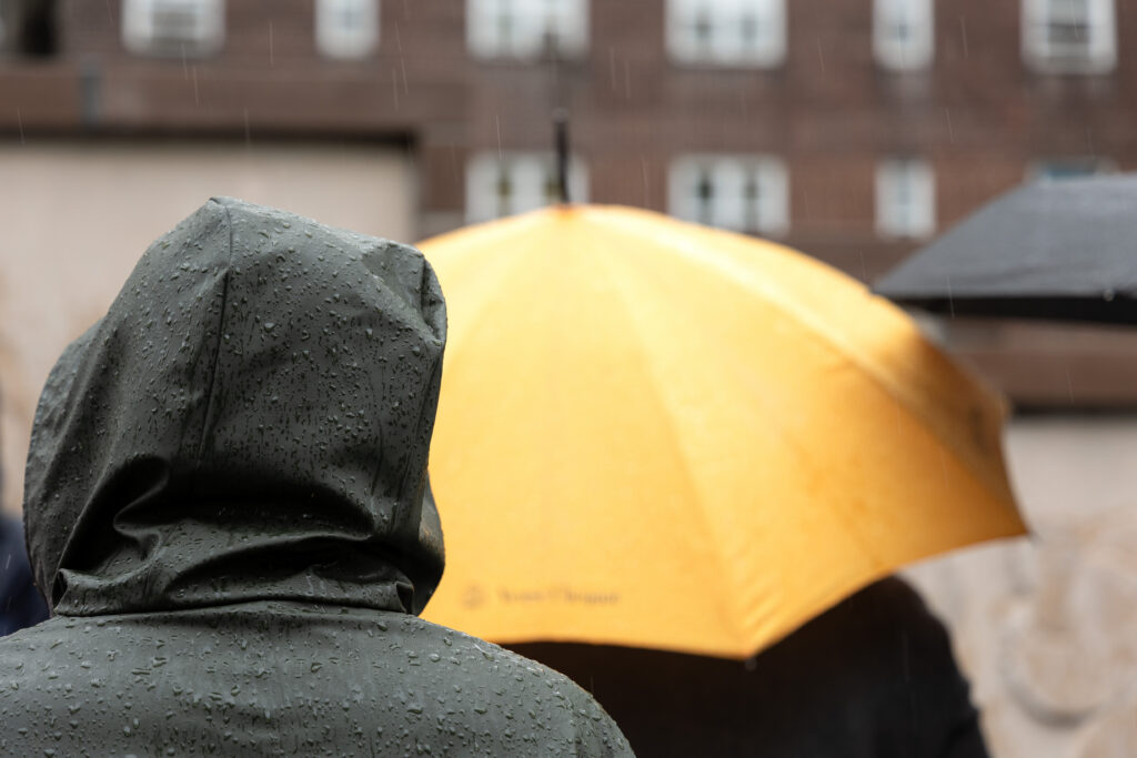 Rain-covered hood and yellow umbrella during a rainy visit to Richmond Barthé’s Exodus and Dance at Kingsborough Houses.