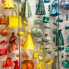 Dior fashion window display arranged by color, from red and orange to yellow, green and teal, illustrating how to wear color well.