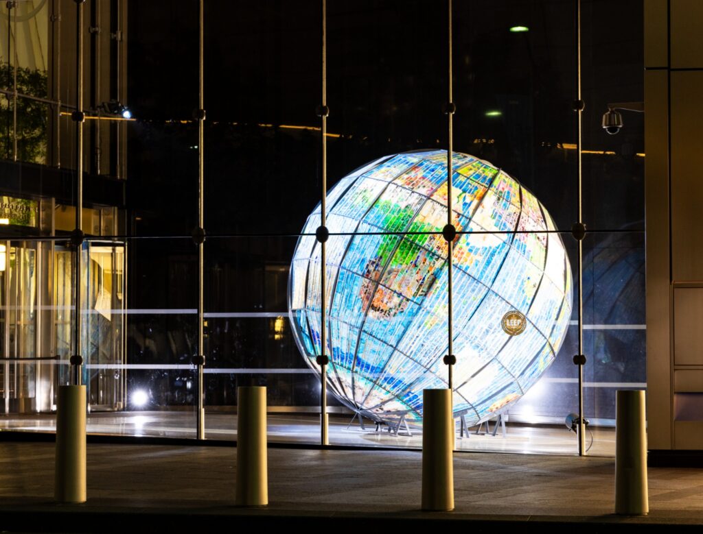 Illuminated globe sculpture at night for Dandelion Chandelier’s June 2026 global luxury events calendar.