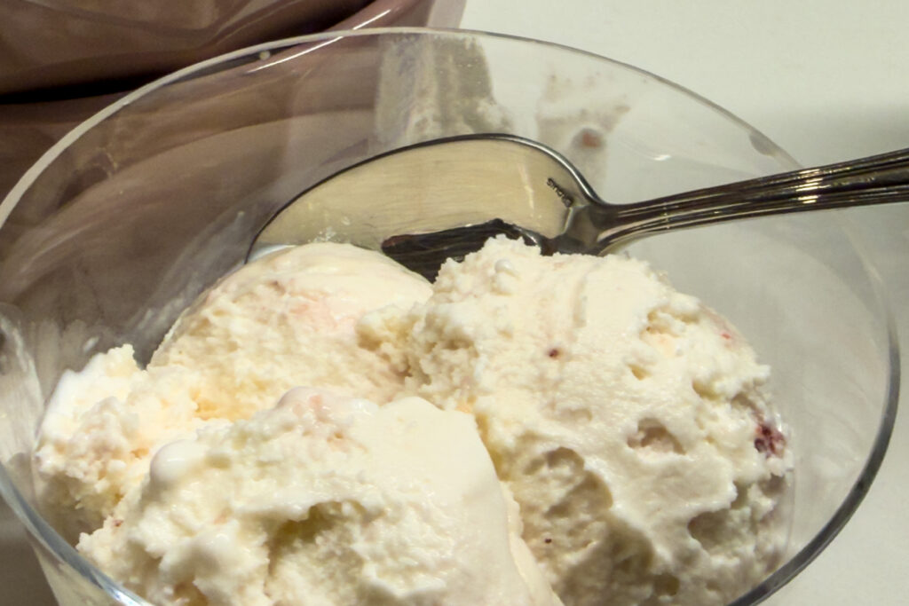 Close-up of pale gourmet ice cream in a vintage coupe with a silver spoon for Dandelion Chandelier’s ice cream guide.