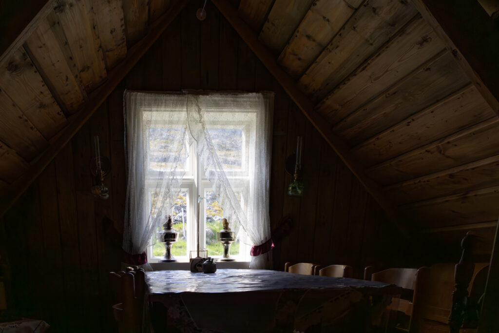 Light filtering through a lace-curtained window inside a timber house in Iceland representing Moonlit Pewter.