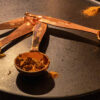 Copper measuring spoons filled with ground spices on a black tray in warm light for Dandelion Chandelier’s best spices to buy online guide.