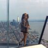 Woman in a checked oversized blazer, sneakers and backpack overlooking New York City, photographed by Pamela Thomas-Graham.