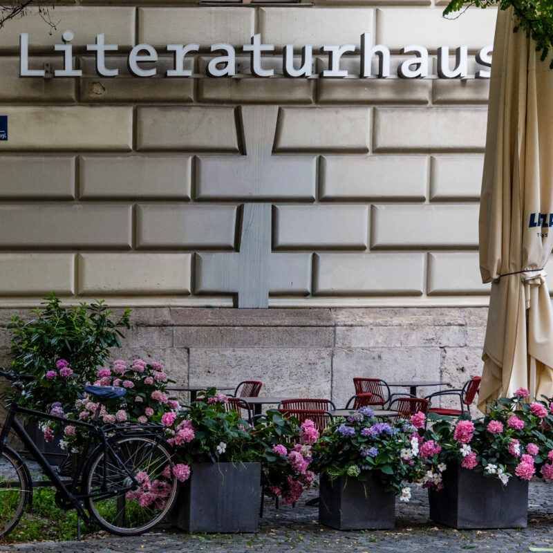 Literaturhaus exterior with bicycle, café seating and summer flowers, featured image for the best new books of August 2026.