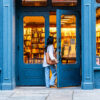 Woman entering a blue independent bookstore at twilight for Dandelion Chandelier’s guide to the best new books of September 2026.