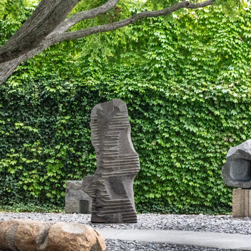 Noguchi Museum sculpture garden with stone works beneath a mature tree in Queens, photographed by Pamela Thomas-Graham.
